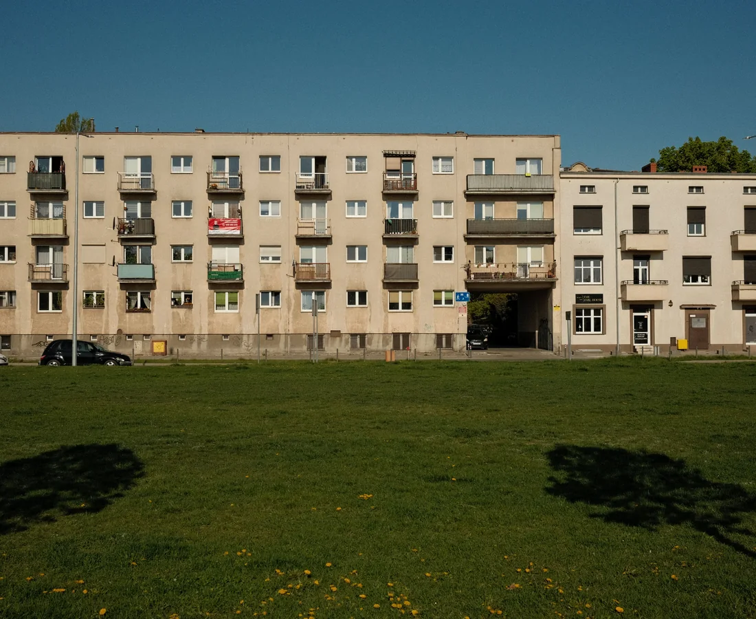 Städtisches Wohnhaus mit Balkonen und einer großen Rasenfläche davor